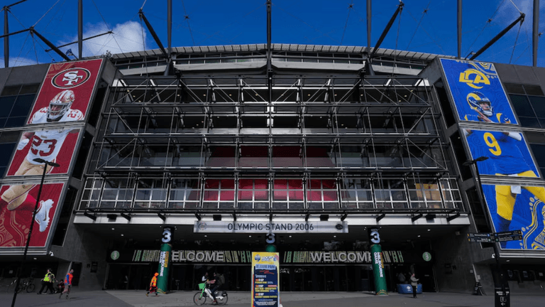 Exterior of a stadium featuring large banners of football players and welcome sign